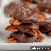 Chocolate turtle candies stacked 3high on a white serving tray and extra turtles in the background.