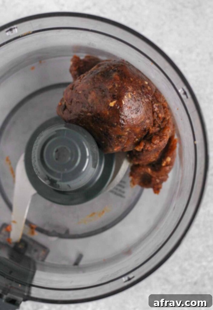 Large ball of blended dates in a food processor.