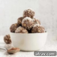 Chocolate Coconut Peanut Butter Balls 10 Chocolate peanut butter energy balls sprinkled with coconut flakes stacked in a small white bowl.