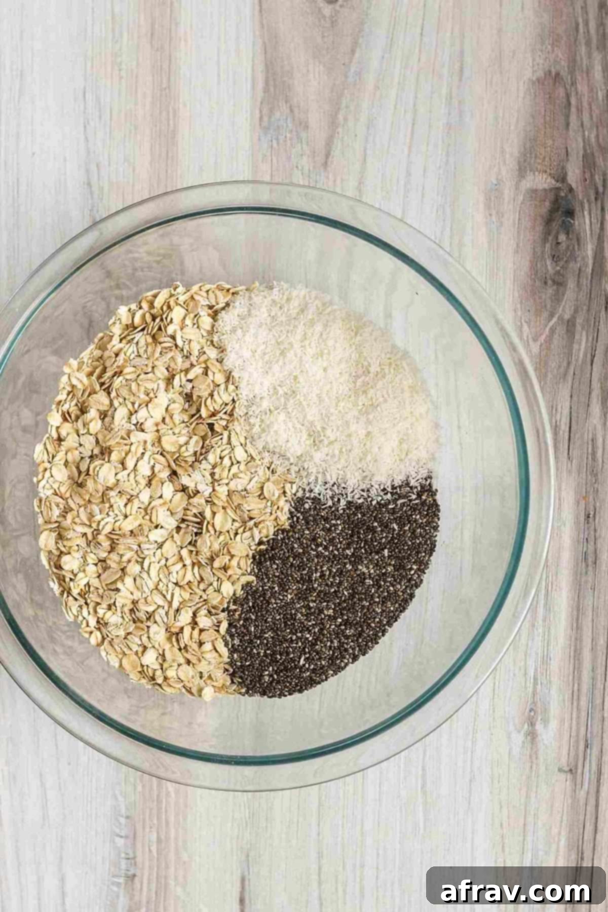 Chocolate Coconut Peanut Butter Balls 4 Oats, coconut flakes, and chia seeds in a glass mixing bowl.