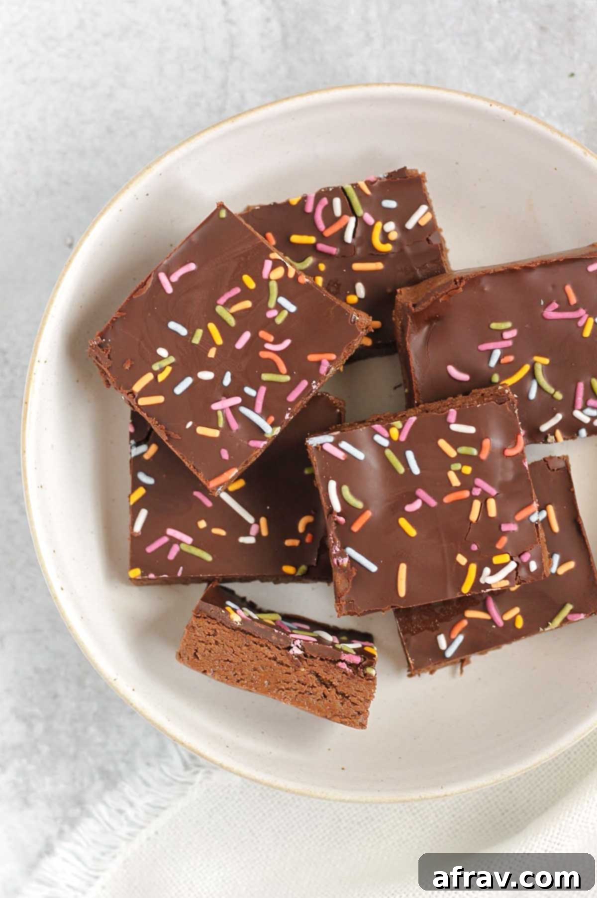 Homemade No-Bake Chocolate Protein Bars 6 Chocolate protein with sprinkles laid out on a white plate.
