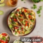 Crispy Air Fryer Fish Tacos 8 Air fryer fish tacos topped with pineapple salsa and arranged on a round plate.