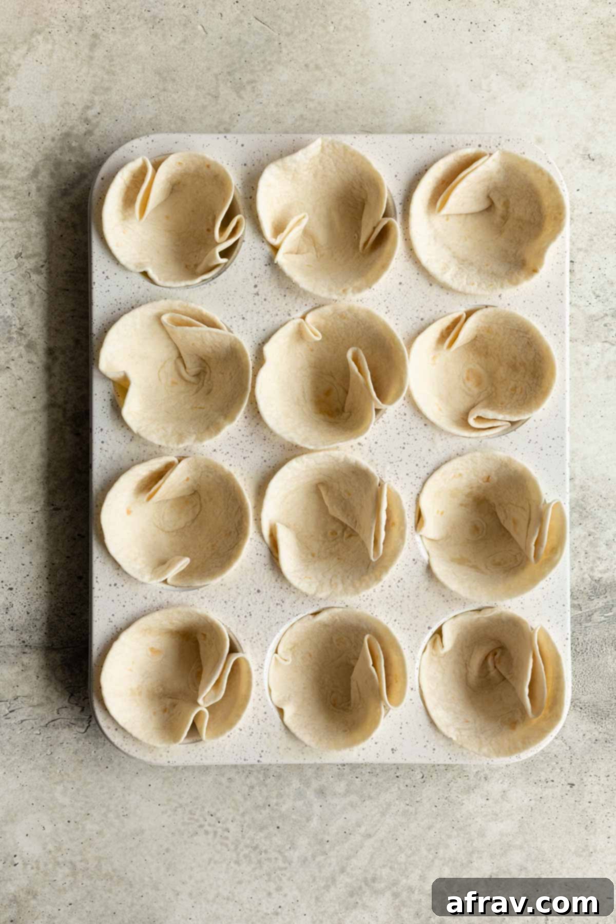 Close-up of a single taco cup filled with seasoned ground turkey and a generous layer of melted cheese, ready for toppings.