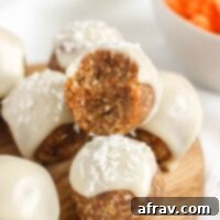 Carrot cake ball topped with glaze bit in half to show texture.