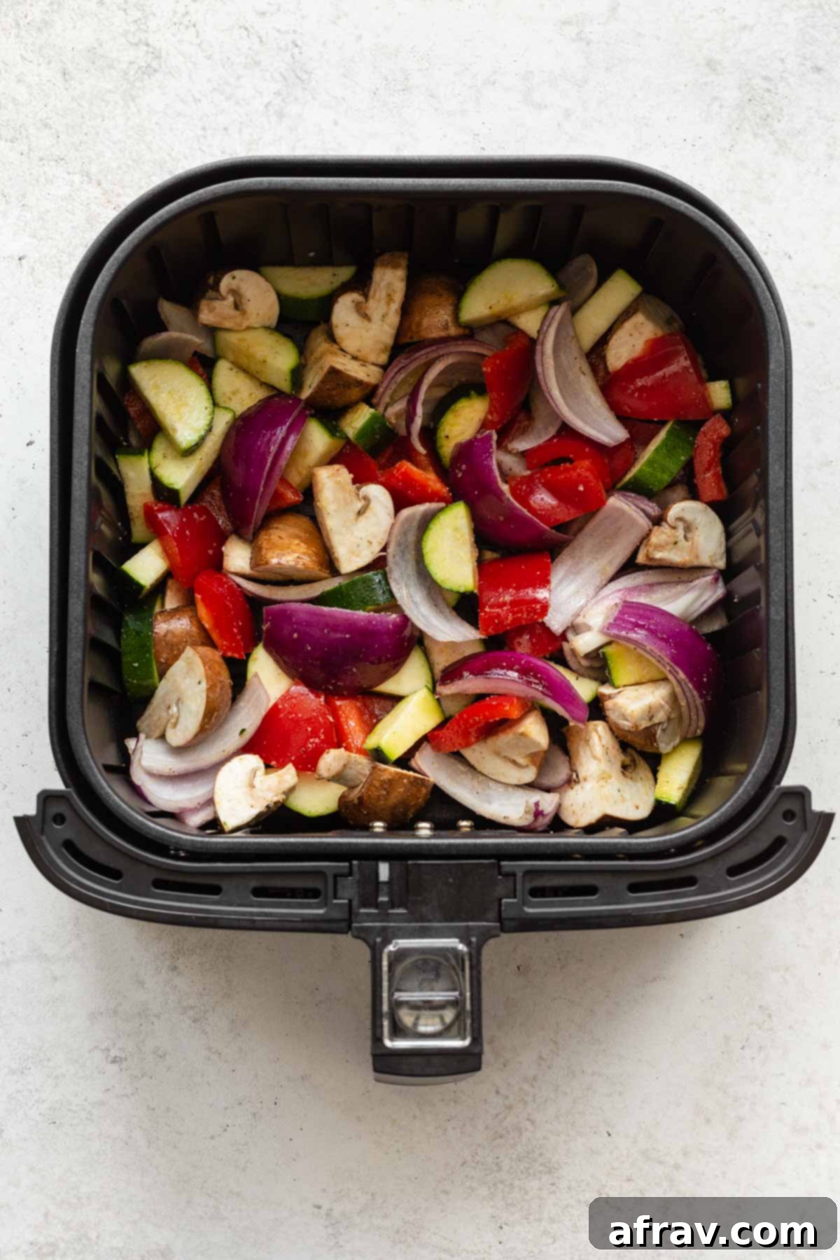 Crispy Air Fryer Veggies 5 Seasoned vegetables arranged in an air fryer basket.