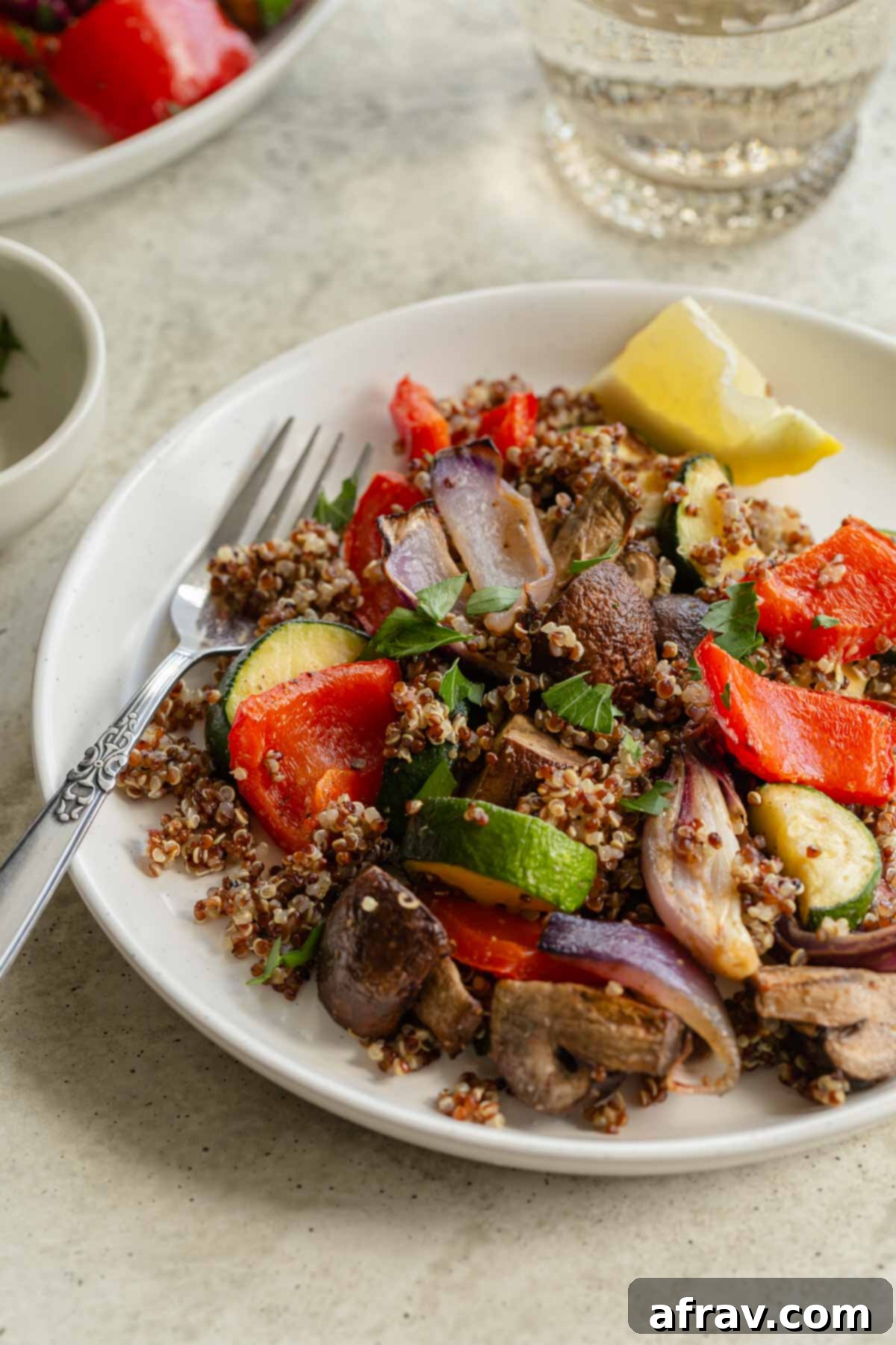 Crispy Air Fryer Veggies 7 Roasted vegetables mixed with quinoa on a white plate with a fork.