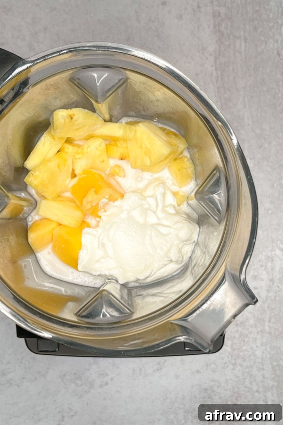 Tropical Mango Pineapple Blend 4 Yogurt, milk, mango, and pineapple in a blender.