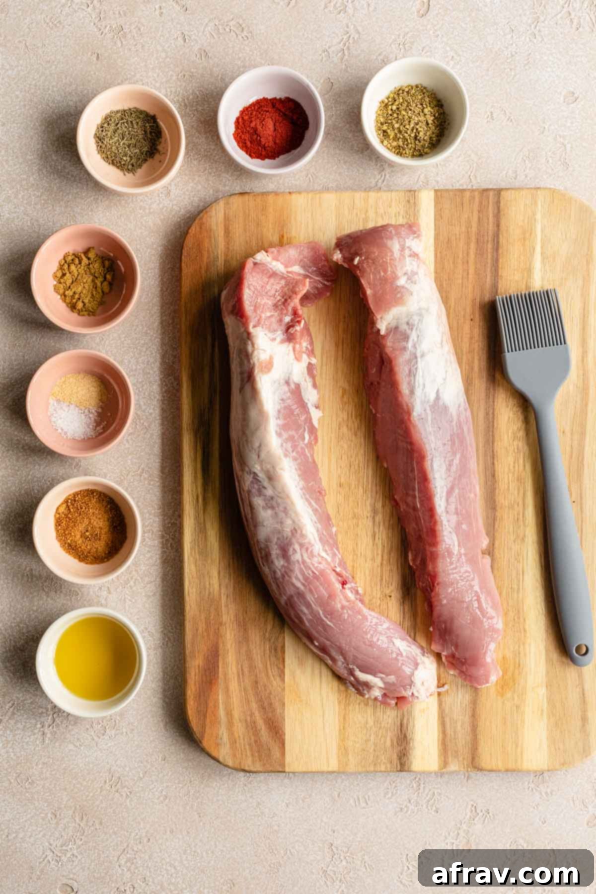 Perfect Air Fryer Pork Tenderloin 4 Overhead view of ingredients to make air fryer pork tenderloin arranged individually, including spices, oil, and pork.