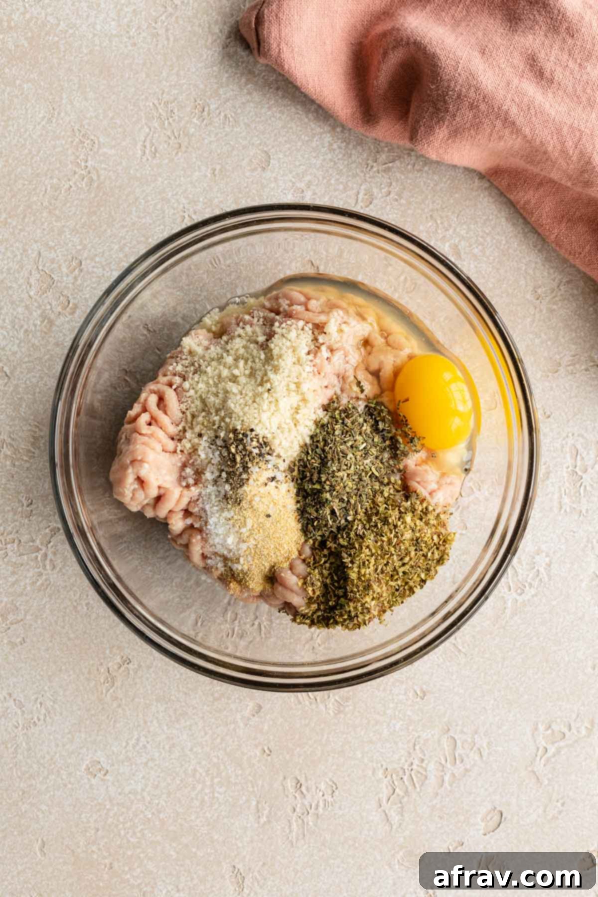 Ingredients to make turkey burgers in a glass bowl.