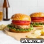 Air fryer turkey burgers arranged on a sheet of brown parchment paper with potato chips on the side.