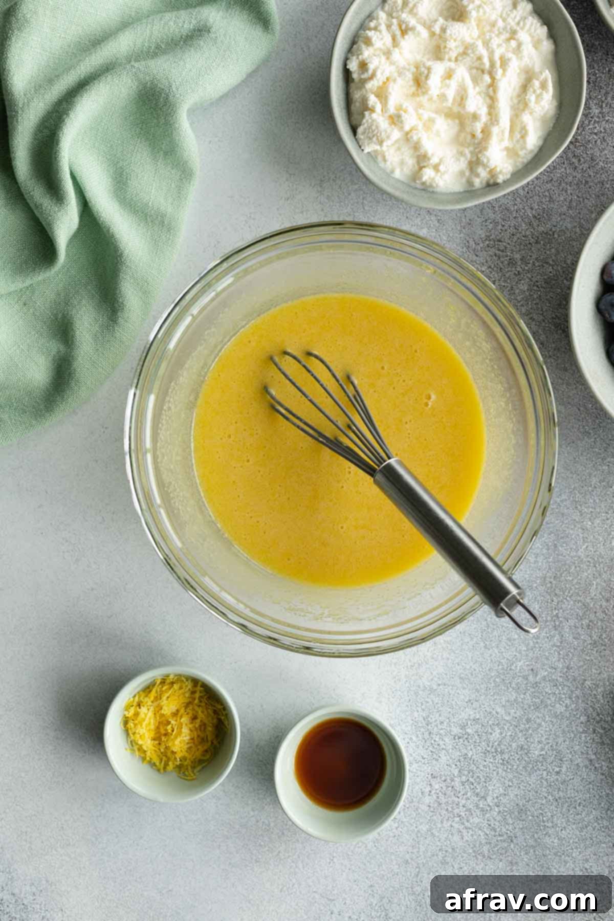 Eggs whisked into the oil and sugar mixture, showing a creamy texture.