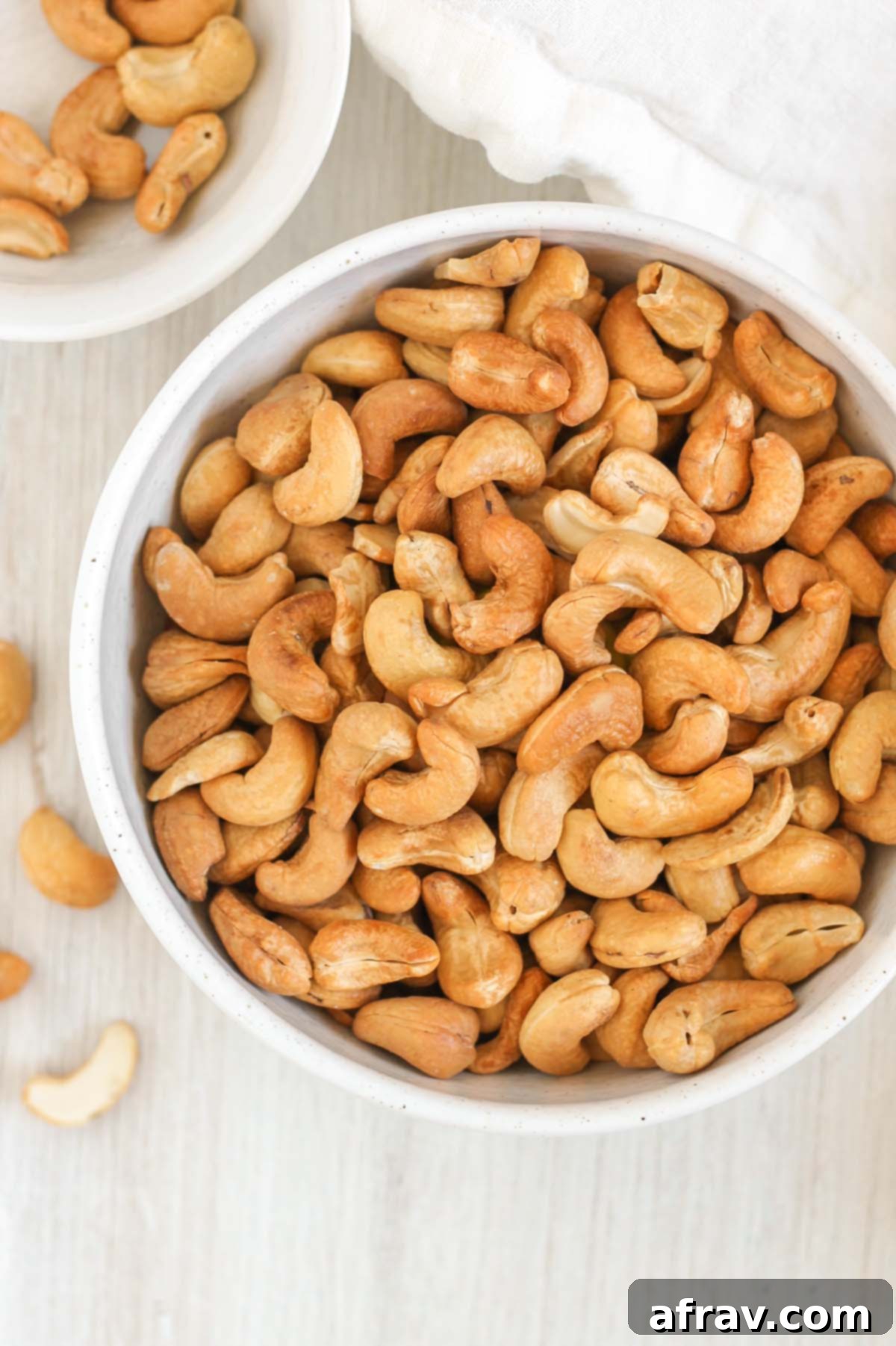 Roasted cashews in a small white bowl.