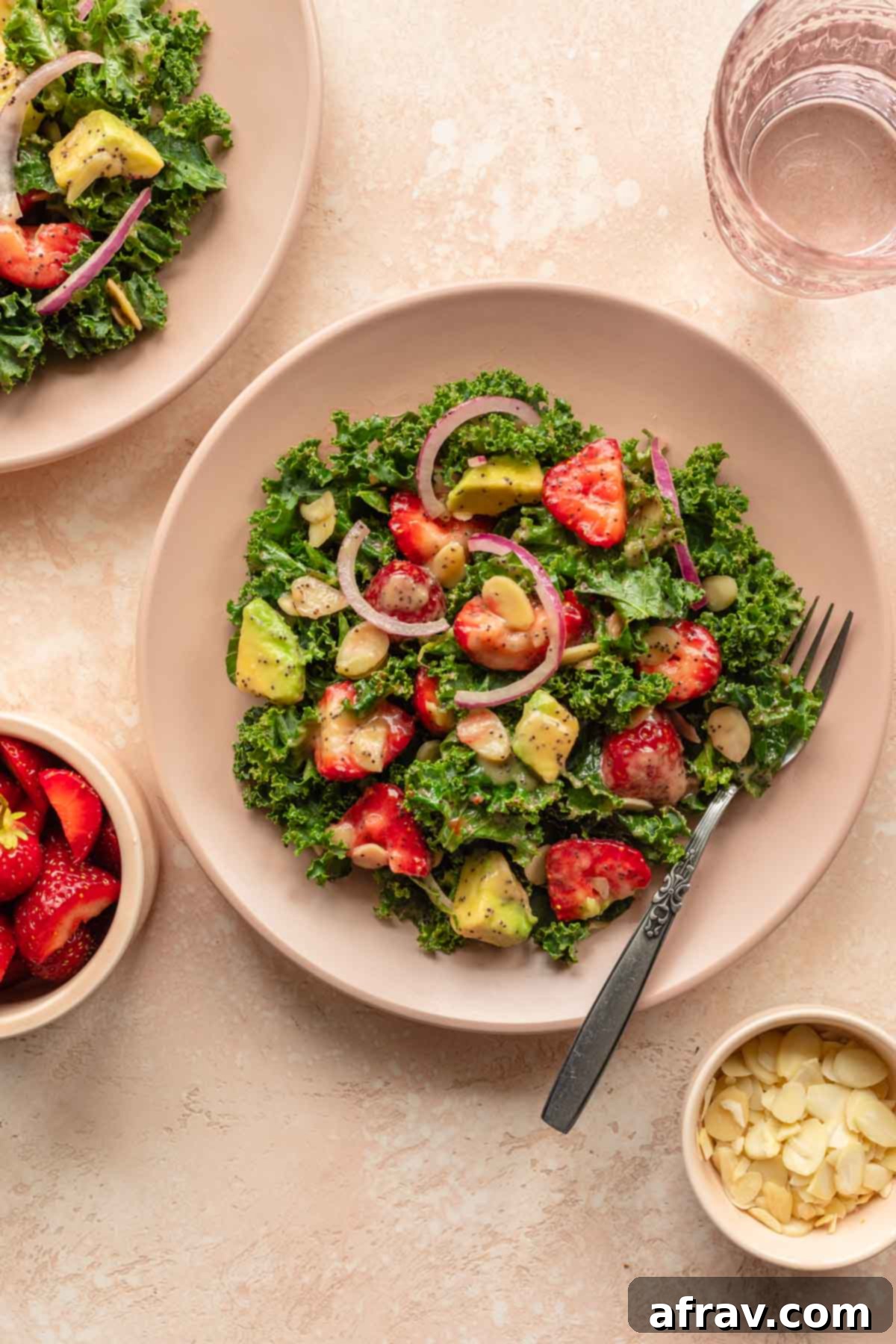 Vibrant Strawberry Kale Salad 2 Overhead of kale strawberry salad on a pink plate with a fork, showcasing vibrant colors.