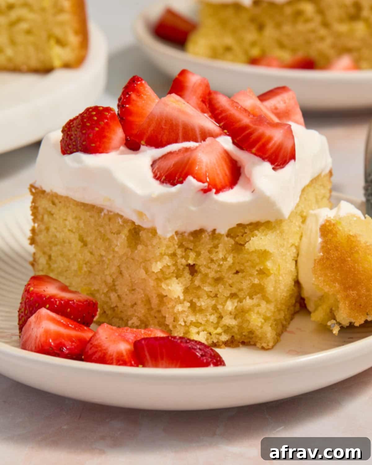 Close up of cake on plate with piece removed by a fork.