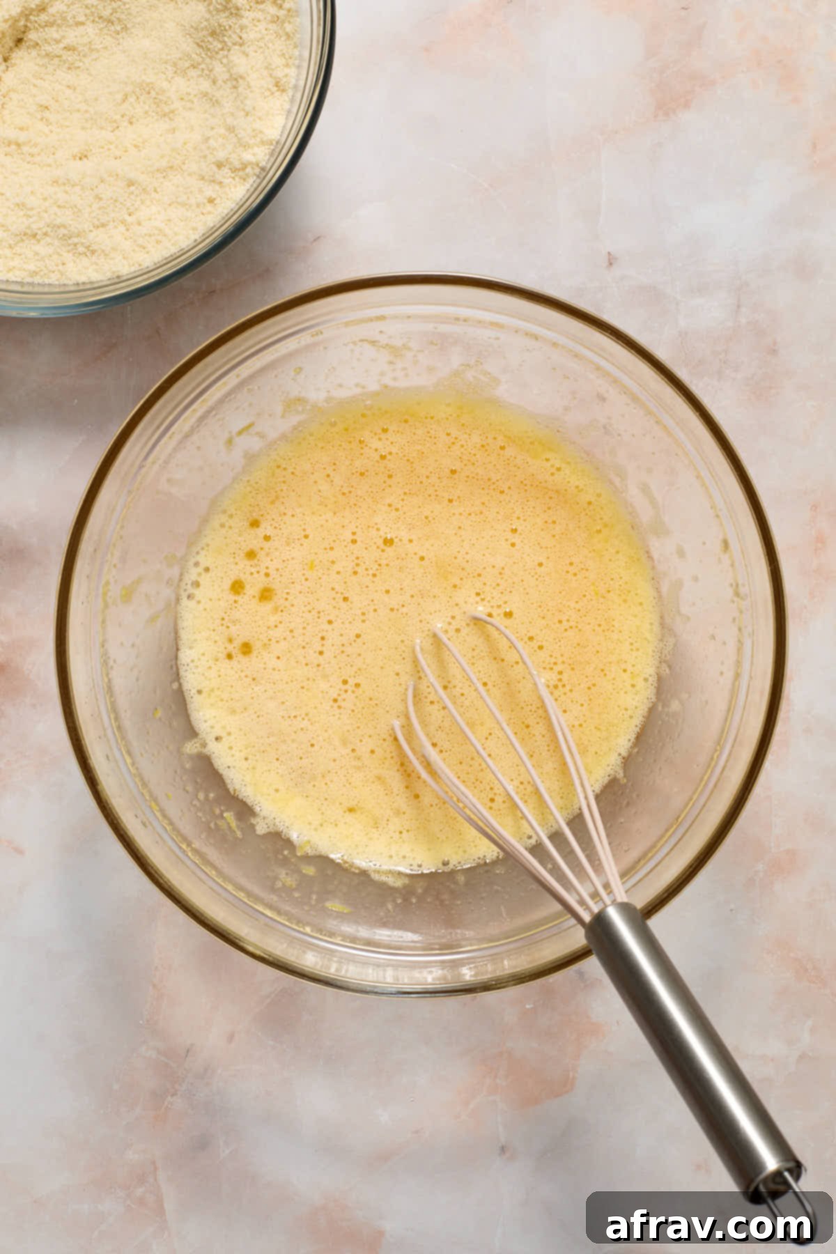 Wet ingredients whisked together with dry ingredients in a bowl on the side.