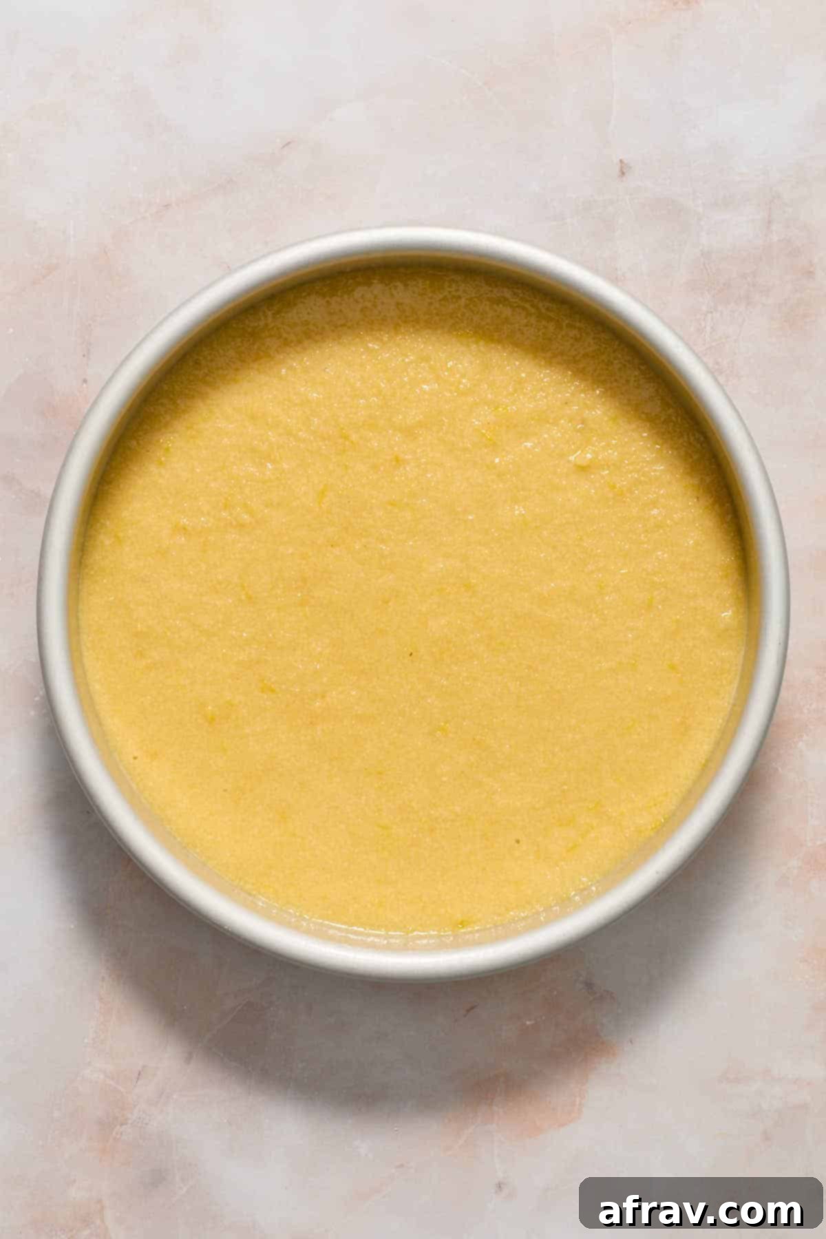 Batter spread out in round cake pan.