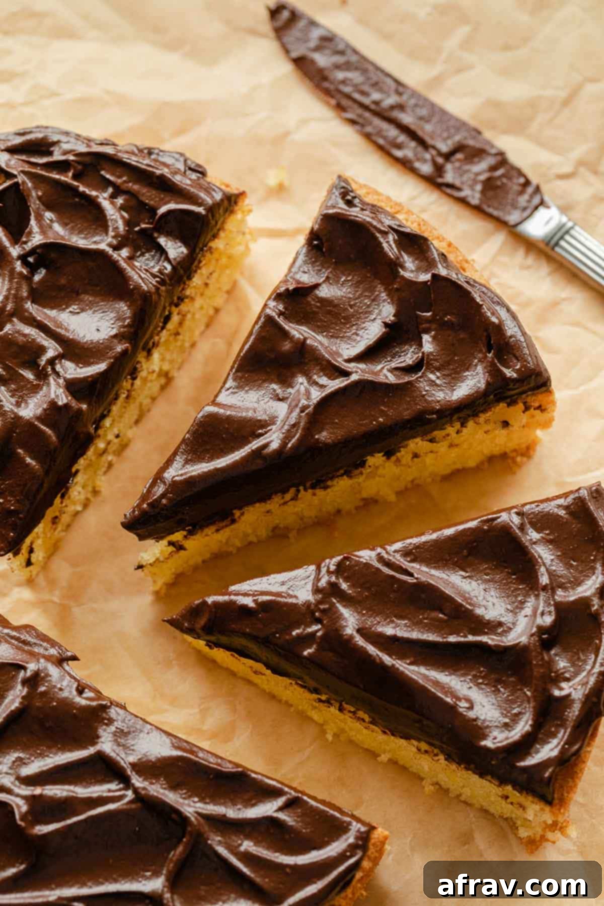 Overhead view of a vibrant lemon cake generously frosted with a rich, dark chocolate avocado icing, showcasing its smooth and creamy texture.