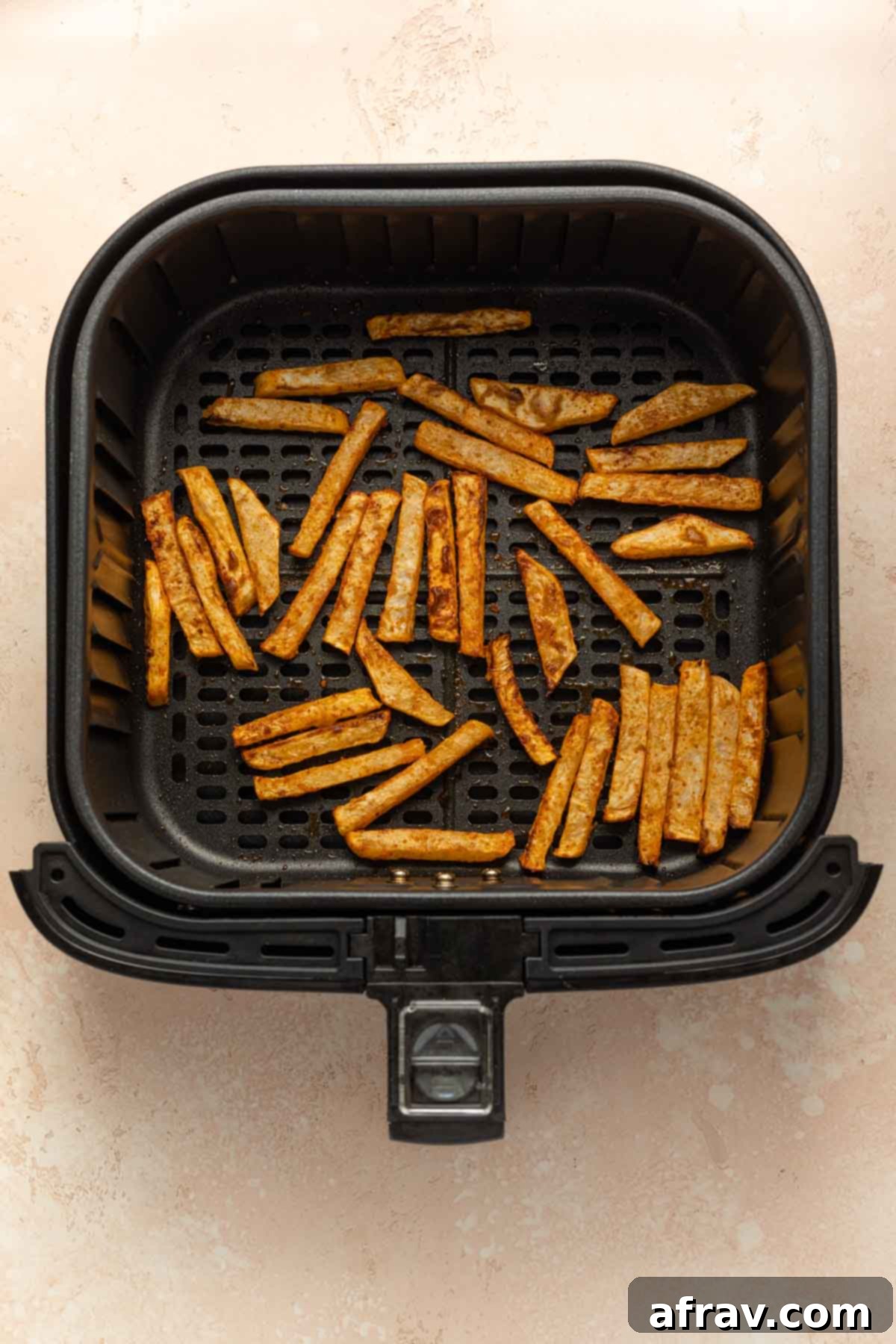 Air fried turnip fries in an air fryer basket.
