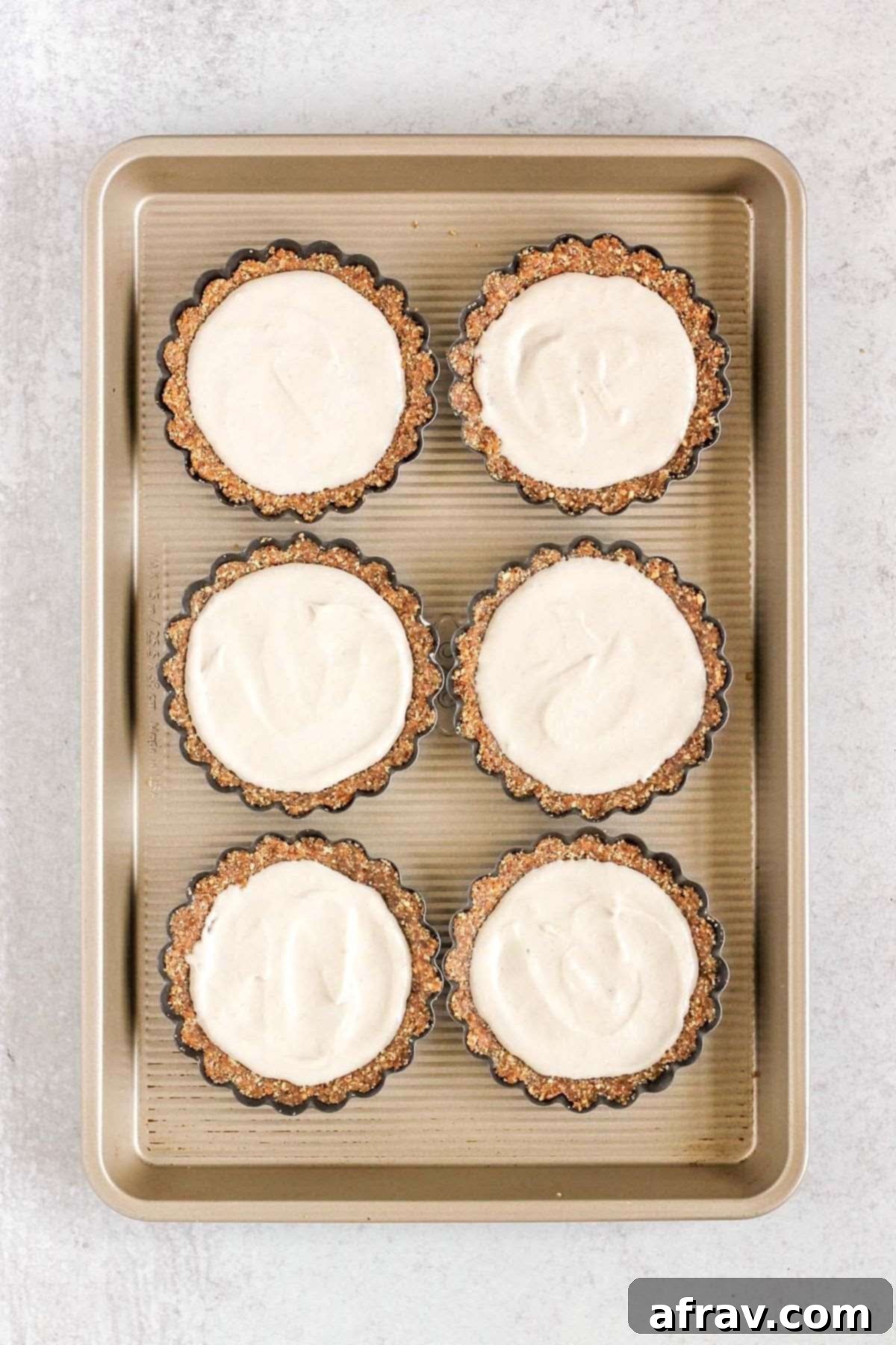 Effortless Fresh Vegan Fruit Tarts 9 Mini tart pans, now filled with the golden-white vegan crust and smooth coconut cream filling, awaiting their fresh fruit topping.