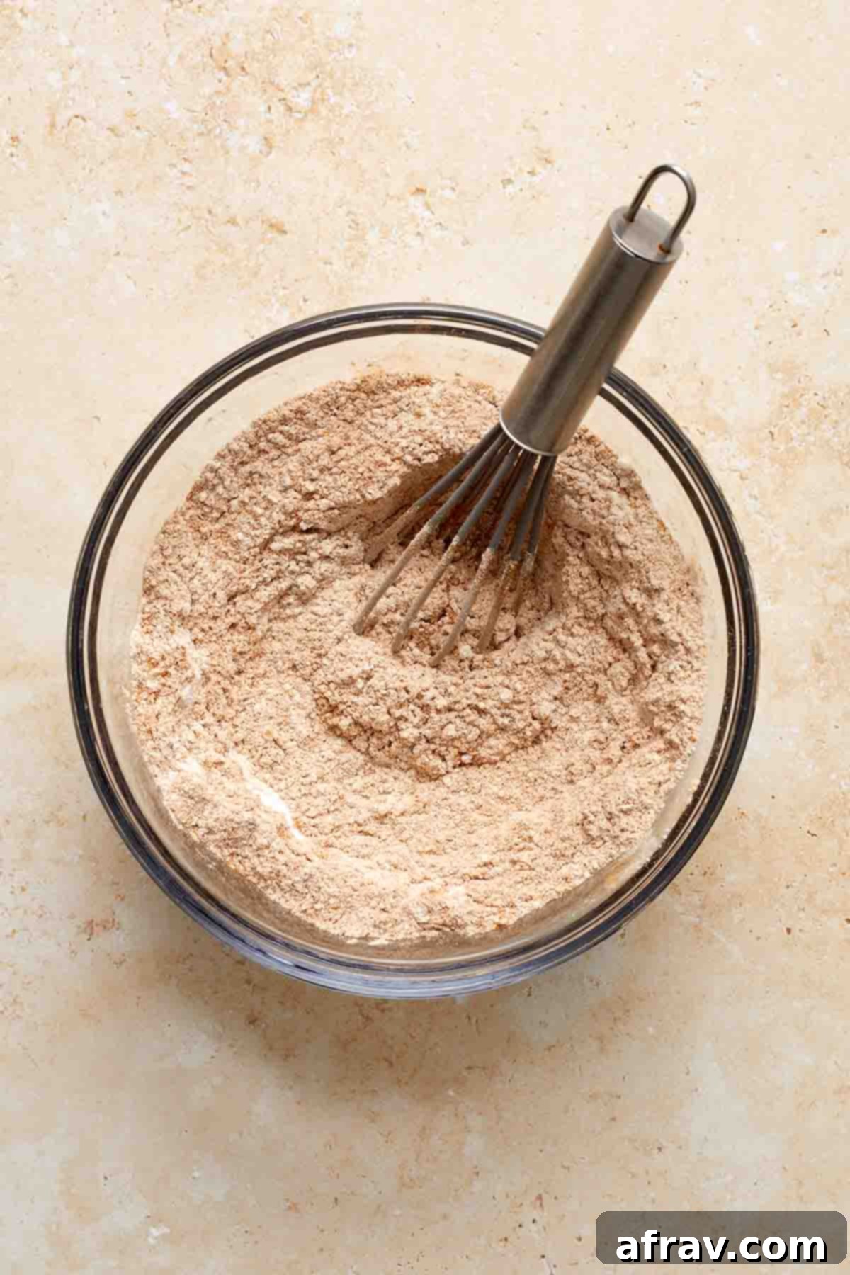 Dry ingredients whisked together in a glass bowl.