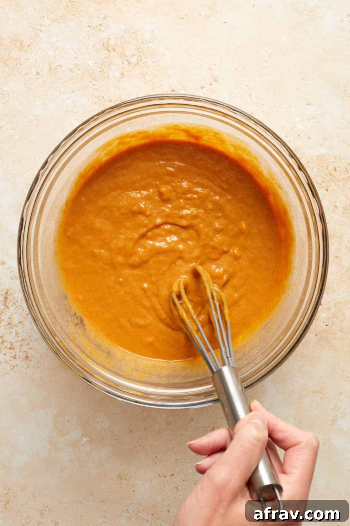 Wet ingredients whisked together in a glass bowl.