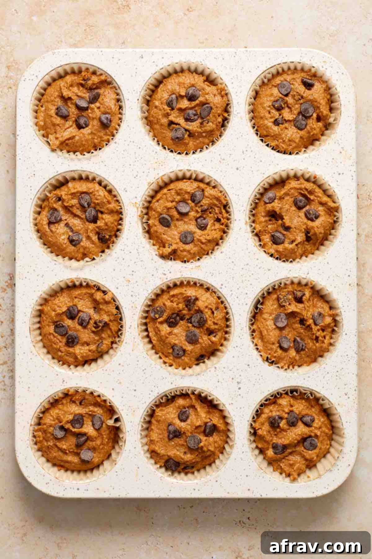 Muffin batter divided into a 12-cup muffin tin.