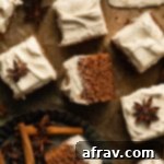 Pieces of apple spice cake with buttercream frosting arranged on a sheet of brown parchment paper, ready to be enjoyed.