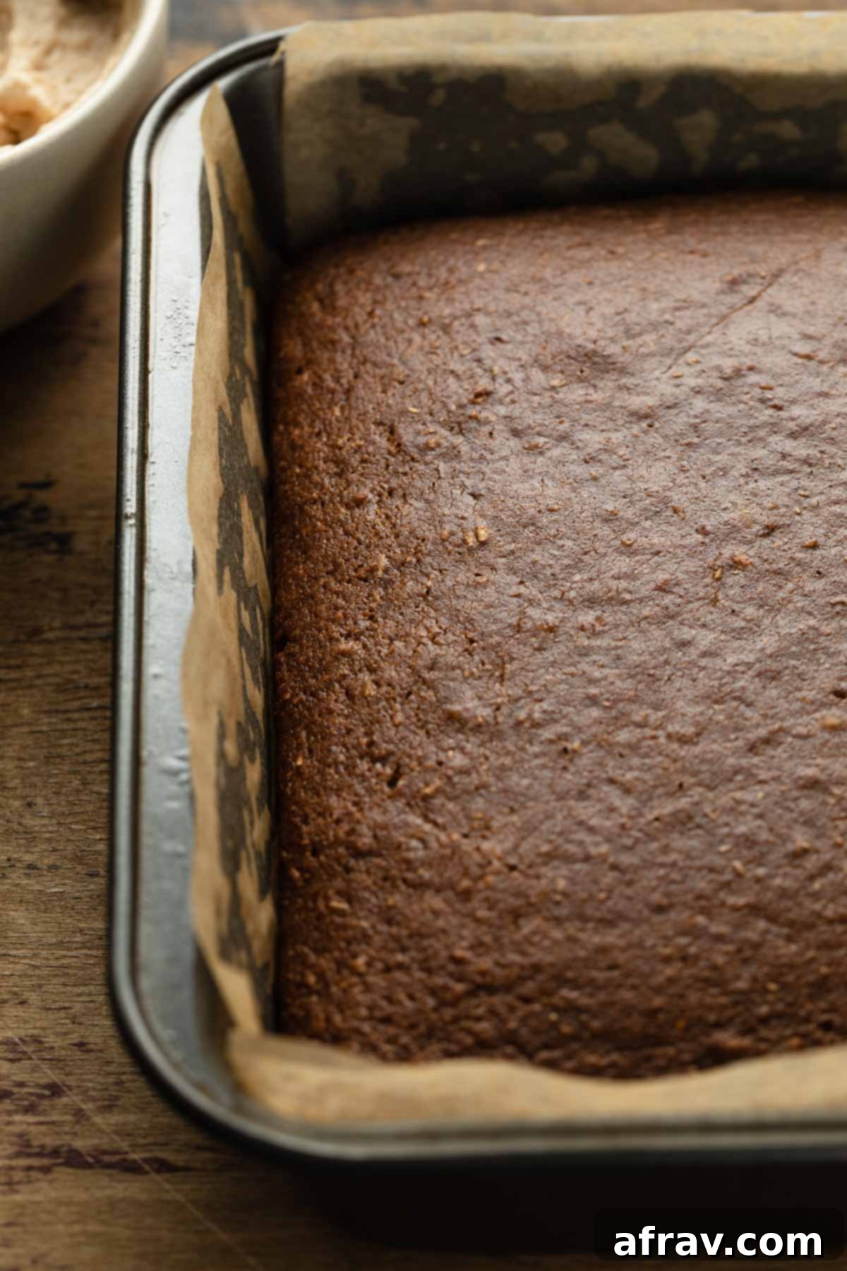 A freshly baked apple spice cake cooling in its square baking pan on a wire rack.
