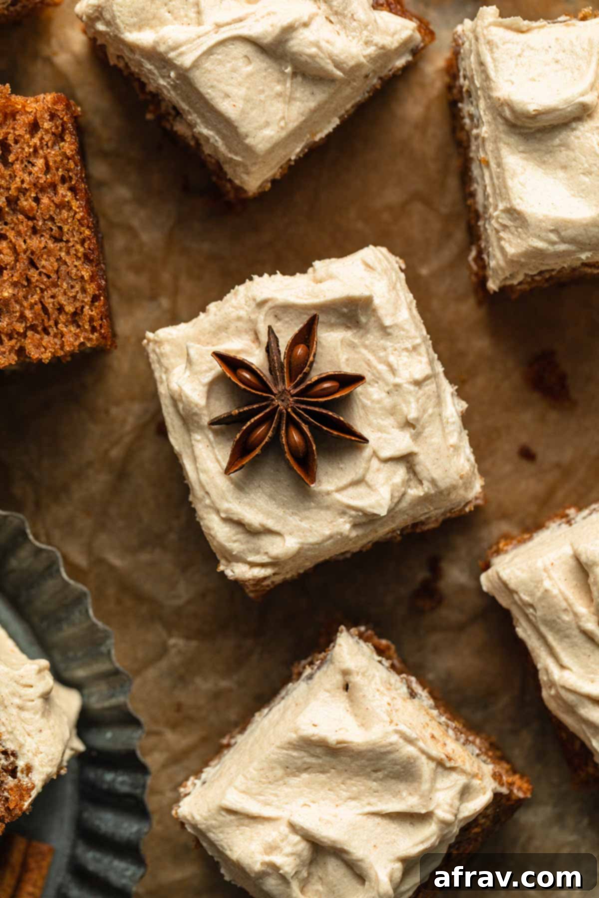 Overhead shot of a slice of apple spice cake, beautifully frosted and garnished with a star anise on top.