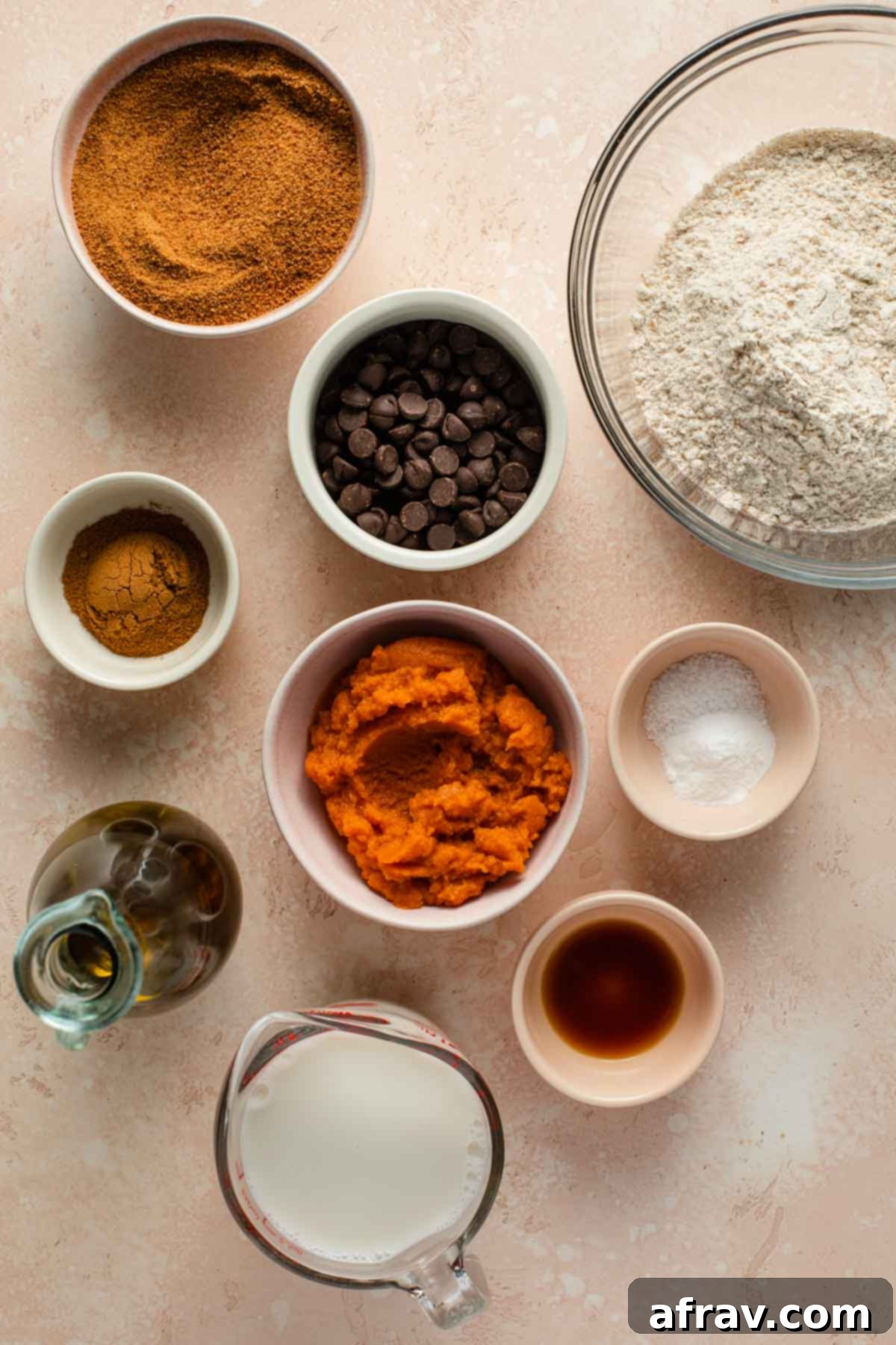 Overhead view of all the fresh ingredients to make pumpkin snack cake, neatly arranged individually on a surface.