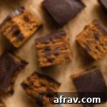 Overhead view of pumpkin snack cake cut into squares and arranged on a sheet of brown parchment paper, ready to be served.