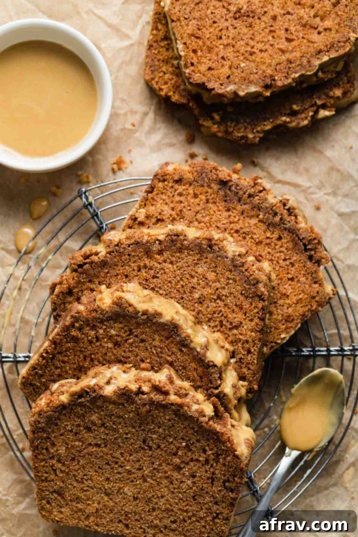 Slices of butternut squash bread arranged on a wire rack, showing the crumb topping and glaze.