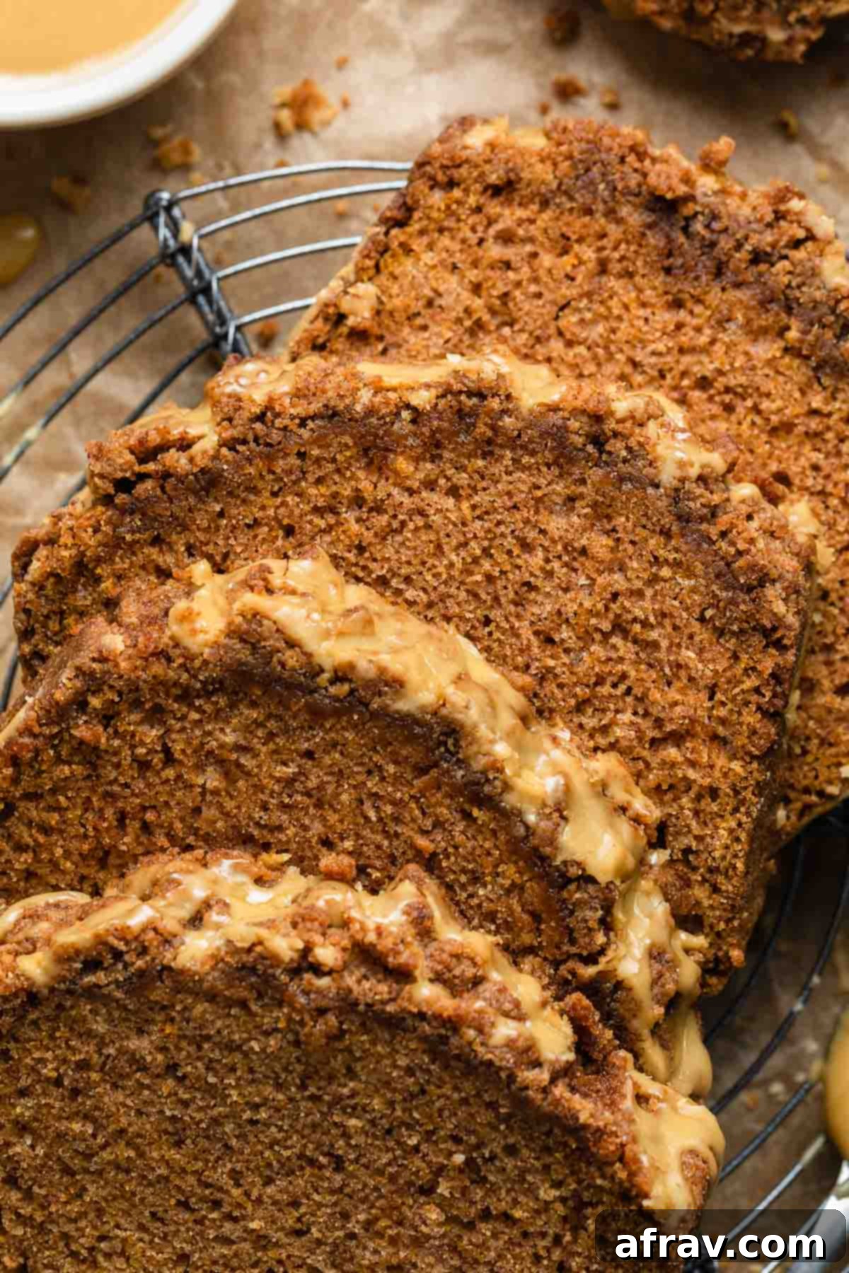 Close up view of several slices of butternut squash bread with crumb topping and maple glaze.