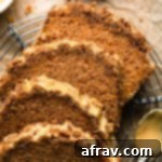 A slice of butternut squash bread with crumb topping and maple glaze on a white plate.