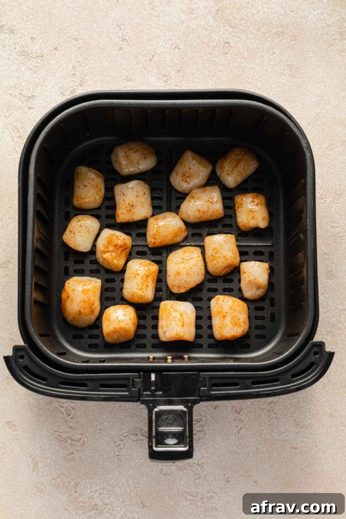 Air Fryer Scallops 5 Scallops arranged in a single layer in an air fryer basket.