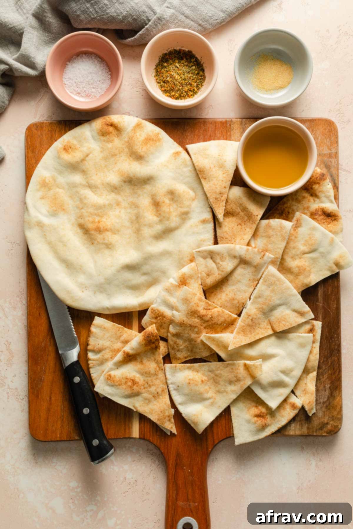 Ingredients to make air fryer pita chips arranged on a wooden board.