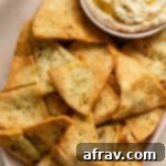 Air fryer pita chips on a platter with a side of dip.