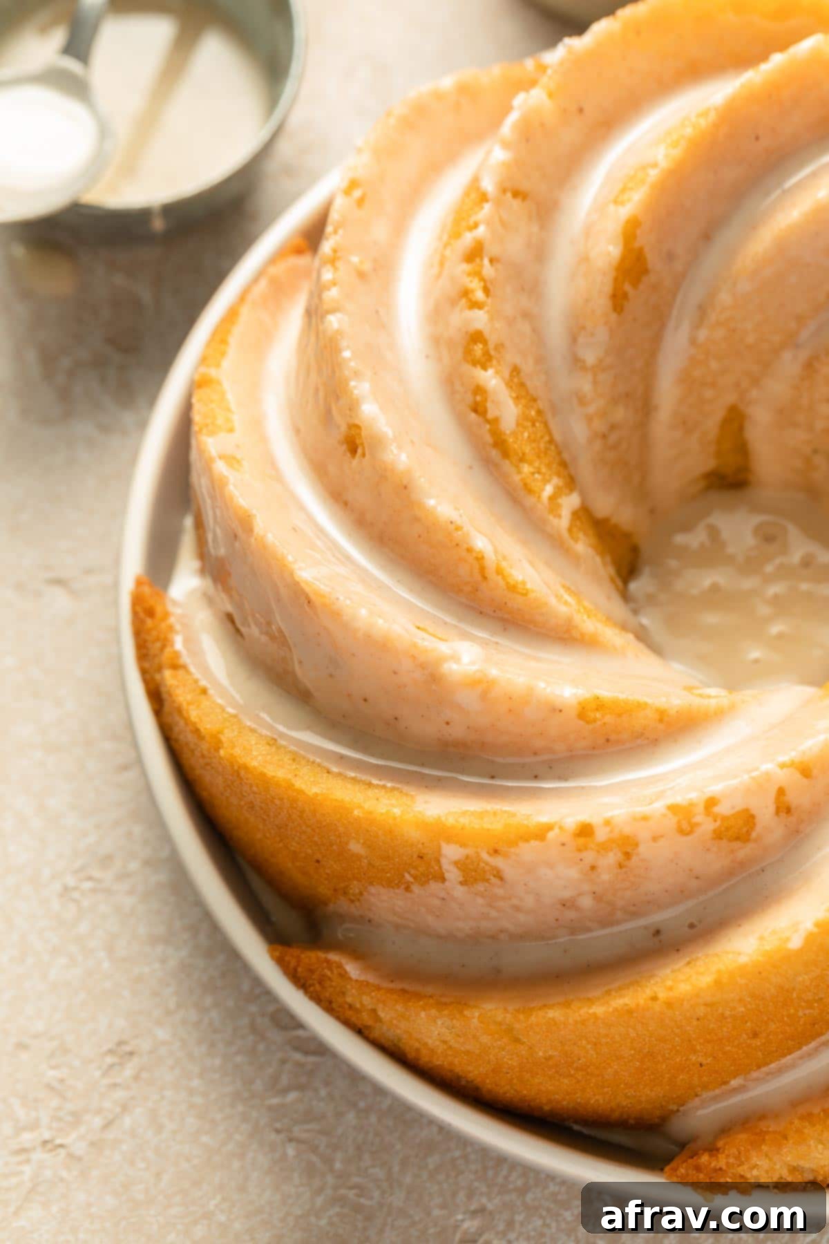 Close-up view of the smooth, sweet glaze dripping down the sides of the Eggnog Bundt Cake, showcasing its festive appeal and delicious texture.