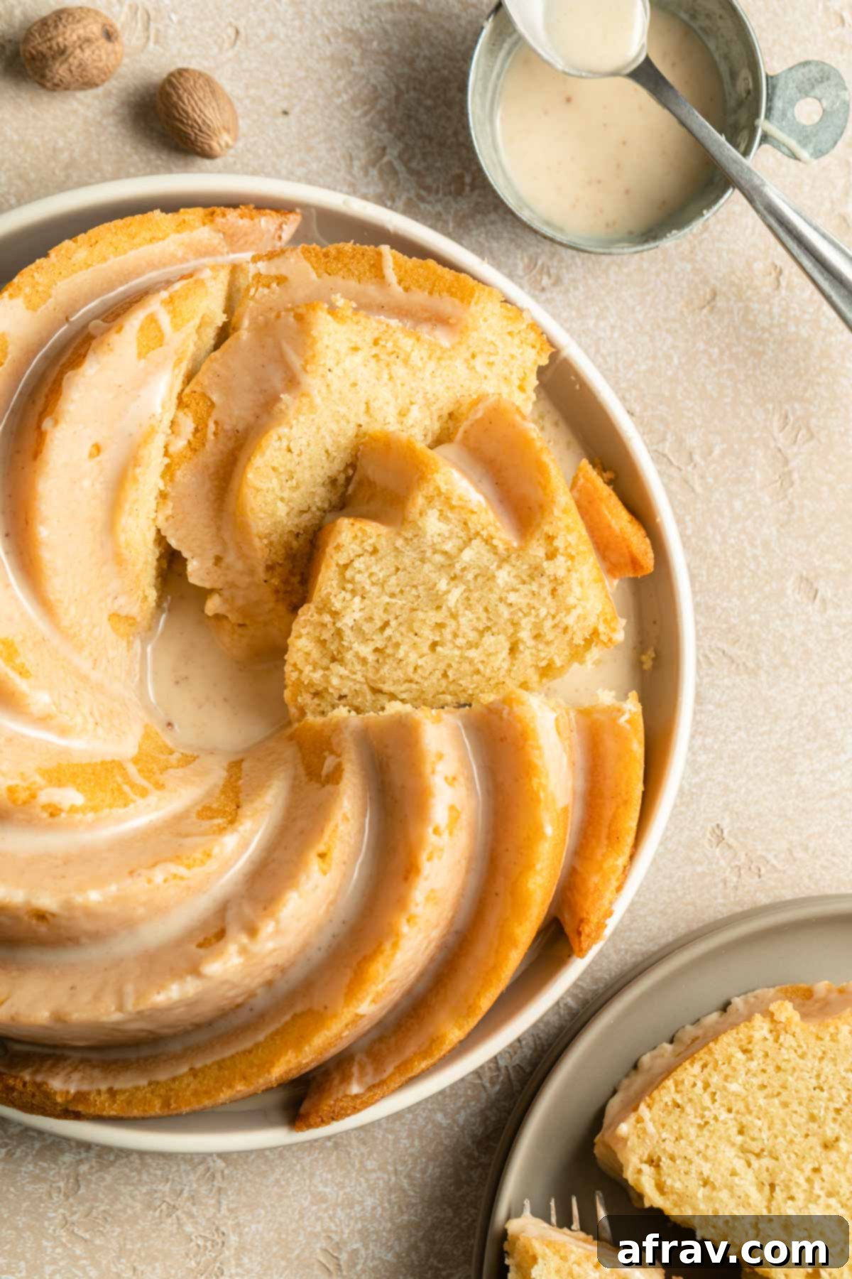 Overhead view of an Eggnog Bundt Cake on a plate, already sliced and ready to be served, showing its moist interior and the golden crumb.