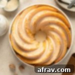 Overhead view of an eggnog bundt cake topped with glaze on a round plate, garnished for the holidays.