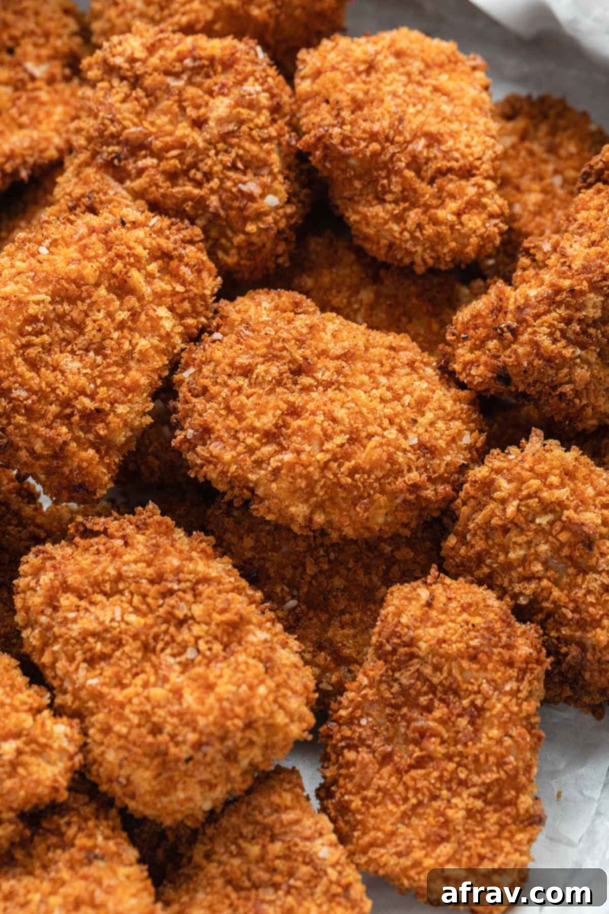 An overhead view of numerous air fryer chicken bites, arranged closely together to show their quantity and golden-brown appeal.