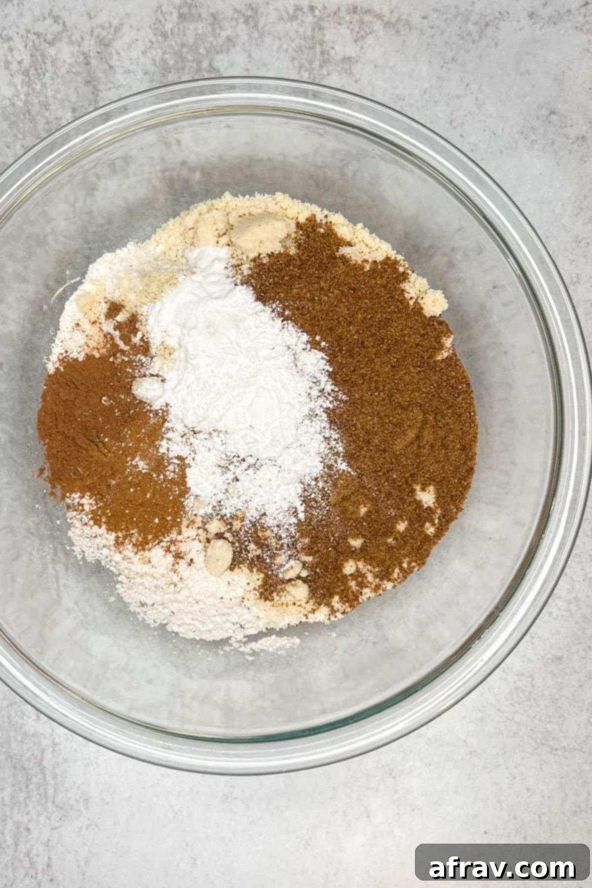 Dry ingredients for gluten-free pumpkin scones in a large glass mixing bowl.