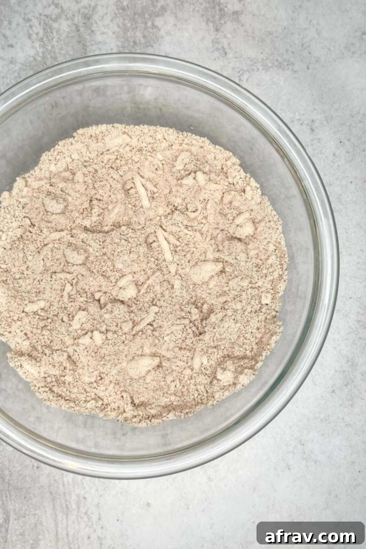 Dry ingredients with butter pieces in a large glass mixing bowl.