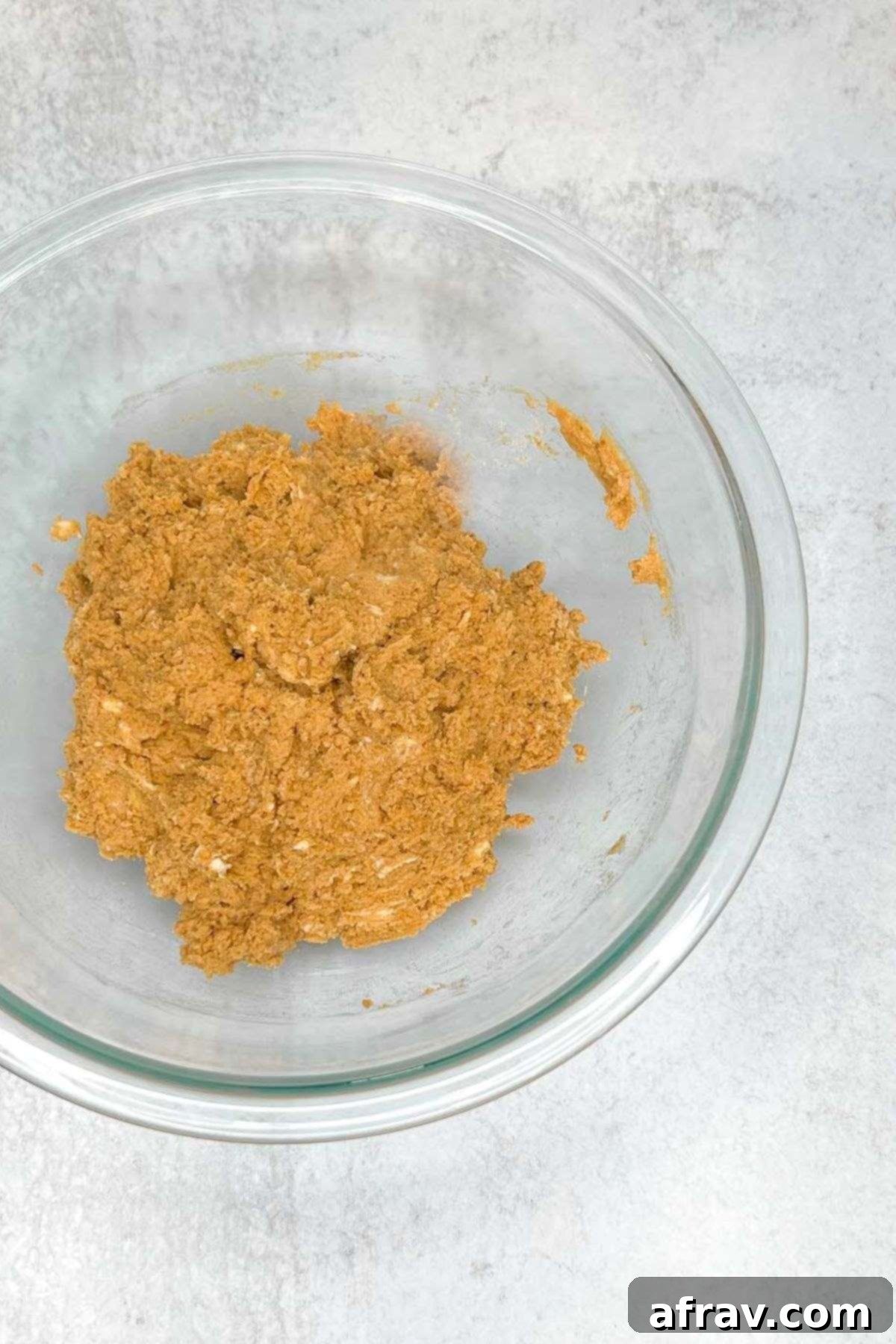Mixed pumpkin scone dough in a glass mixing bowl.