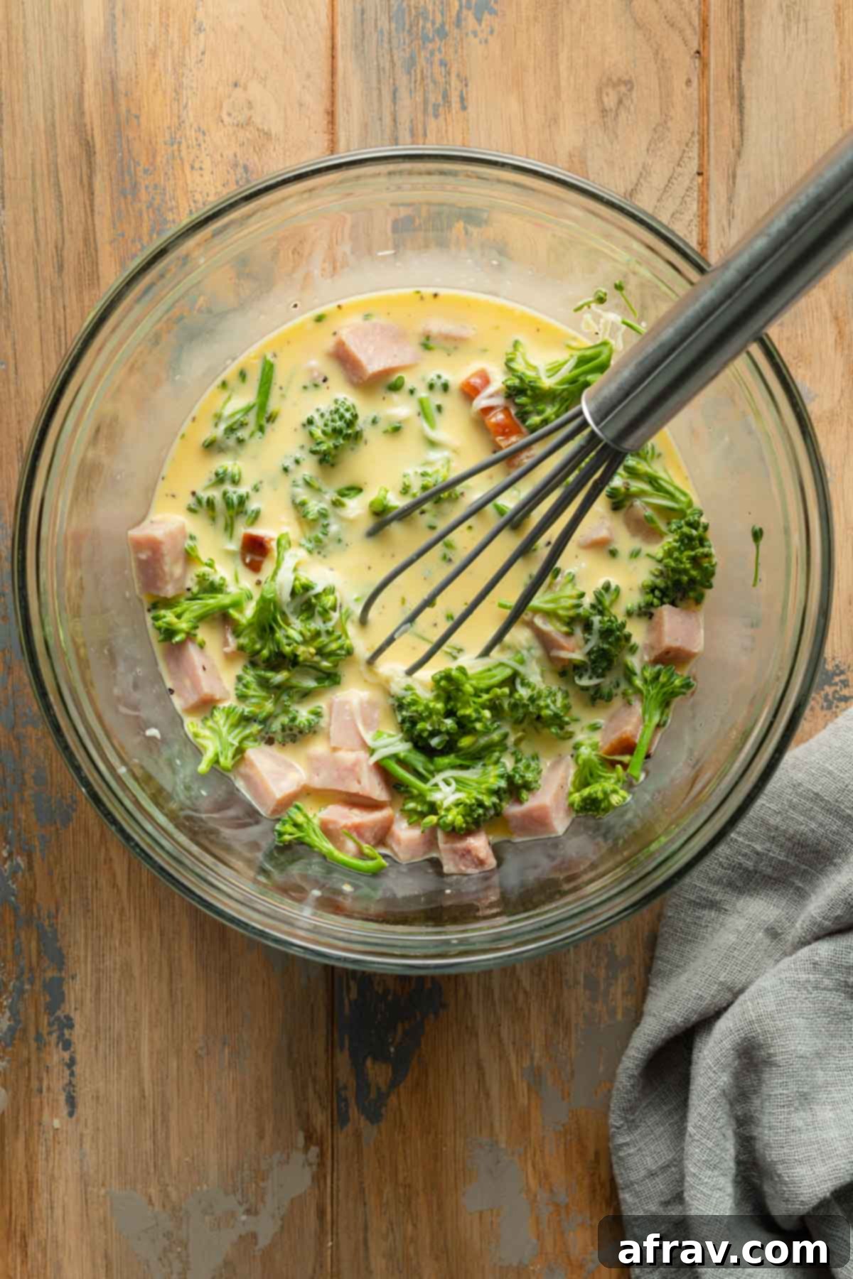 Quiche filling whisked together in a glass bowl.