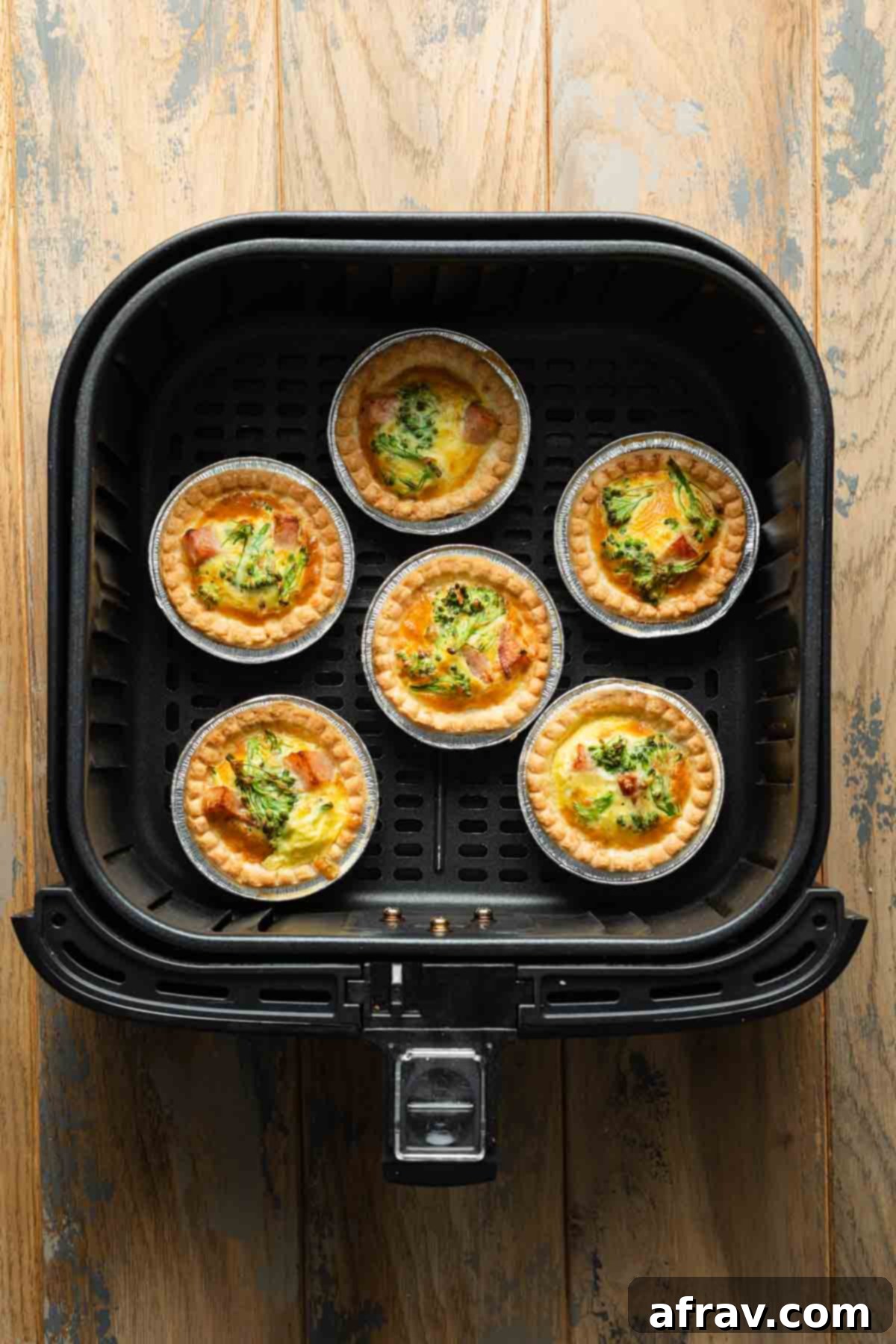 Cooked mini quiches in an air fryer basket.