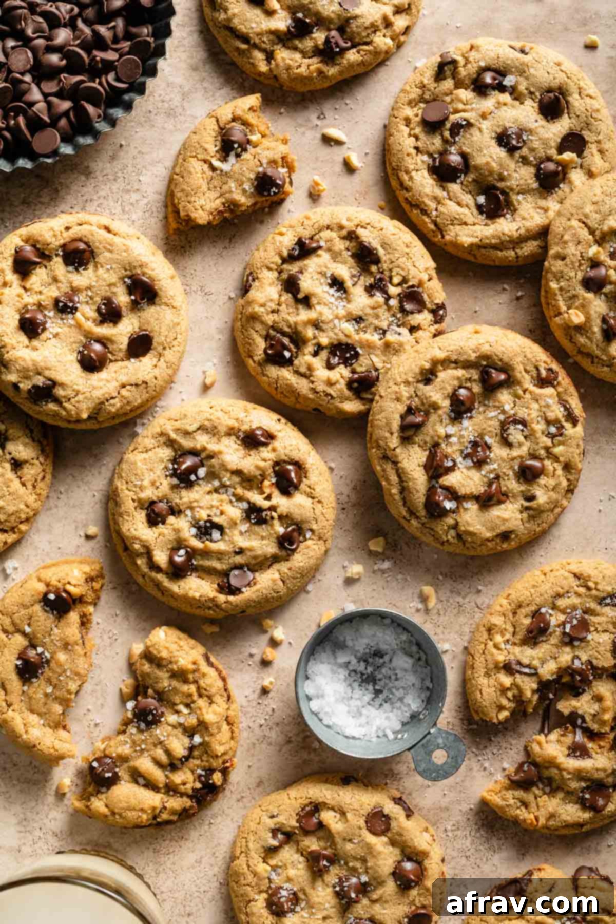 Oat flour cookies spread out on a surface with chocolate chips and sea salt, showcasing their inviting texture.