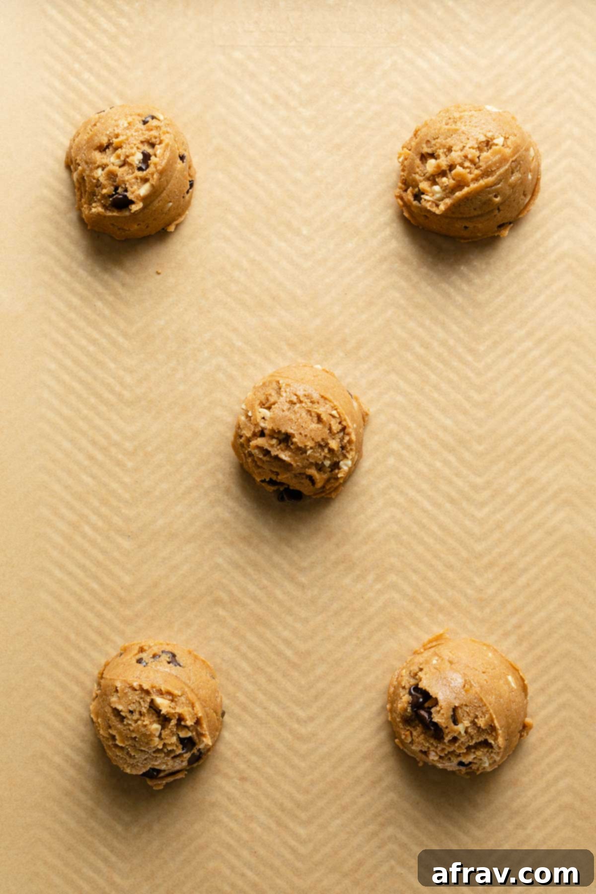 Perfectly scooped cookie dough balls arranged on a baking sheet, ready for the oven, with good spacing between each.