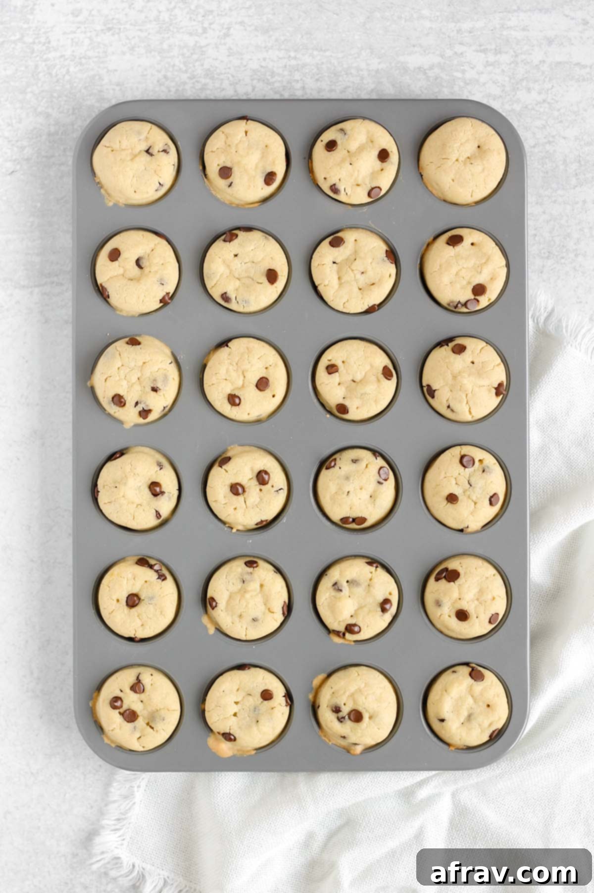 Gluten-Free Dairy-Free Mini Chocolate Chip Muffins 5 Mini chocolate chip muffins baking in a 24-cup muffin tin.