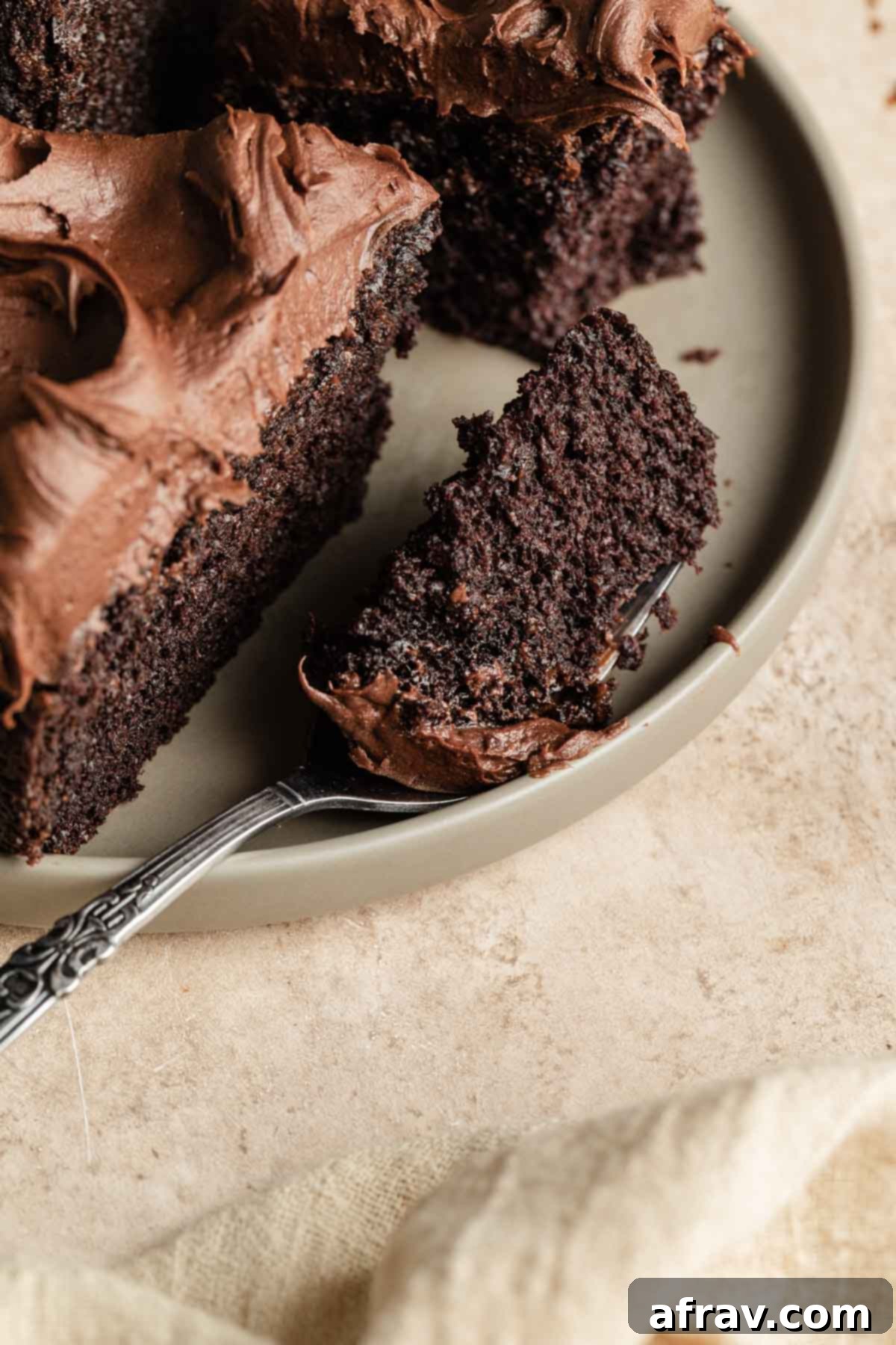 Side view of a forkful of cake on a beige plate.